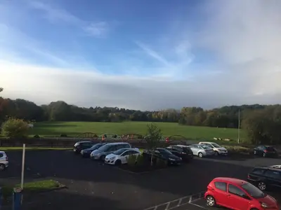 a parking lot with a bunch of cars parked at Alona Hotel in Motherwell