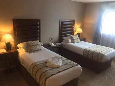a hotel room with two beds and a window at Alona Hotel in Motherwell