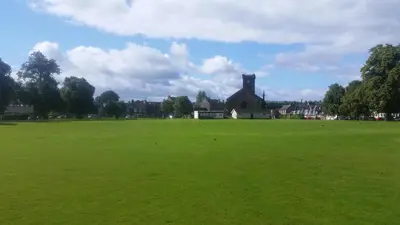 a large green field with a large house in the background at Blair Drummond Holiday Home in Doune