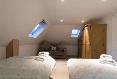 a attic bedroom with two beds and a couch at Blair Drummond Holiday Home in Doune