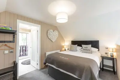 a bedroom with a bed and a heart on the wall at Loch Lomond Luxury Lodges in Drymen