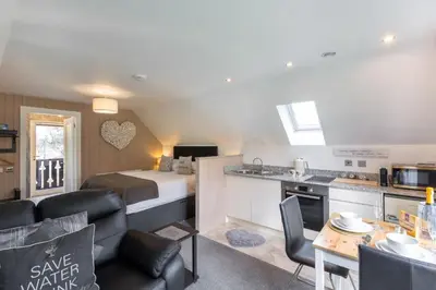 a room with a bed and a kitchen with a table at Loch Lomond Luxury Lodges in Drymen