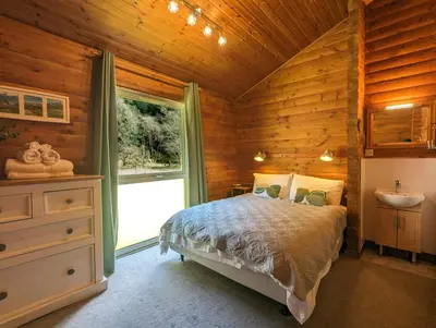 a bedroom with a bed and a sink in a room at Ruskin Lodges Argyll, by Puck's Glen, Rashfield near Dunoon in Dunoon