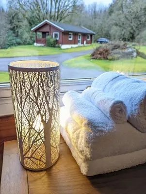 a pile of towels sitting on a table next to a window at Ruskin Lodges Argyll, by Puck's Glen, Rashfield near Dunoon in Dunoon