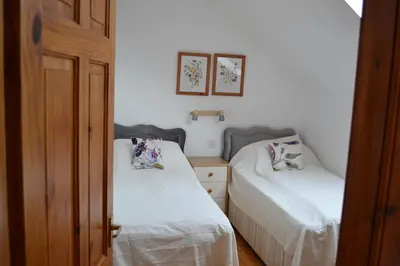 two beds in a small room with white sheets at Oban Seil Farm in Clachan
