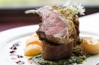 a piece of meat sitting on a white plate at Loch Melfort Hotel in Ardfern