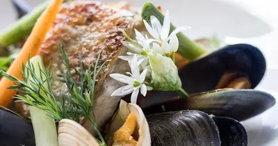 a plate of vegetables with flowers on top of them at Loch Melfort Hotel in Ardfern