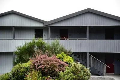 a building with a dog sitting on a balcony at Loch Melfort Hotel in Ardfern