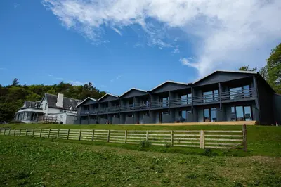 a large house with a fence in front of it at Loch Melfort Hotel in Ardfern