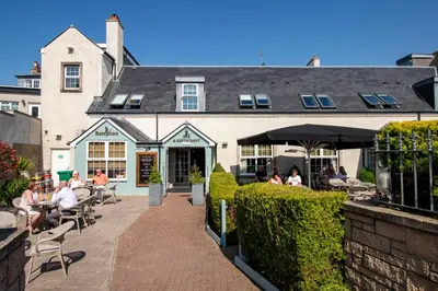 people sitting at tables outside of a building at The Loans Inn in Troon