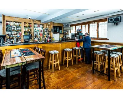 a man standing at a bar in a restaurant at The Crown in Callander