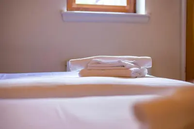 a white bed with a towel on top of it at The Crown in Callander