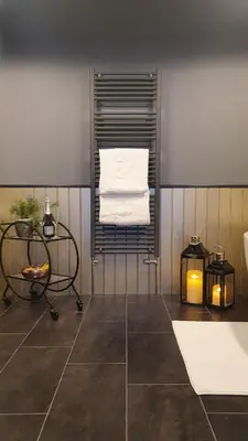a bathroom with a towel rack and a bath tub at Rose Villa in Oban