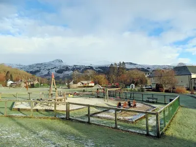 a group of people sitting in a playground at Gracedieu in Killin