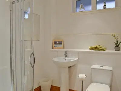 a white bathroom with a toilet and a sink at Bruichladdich in Rothesay