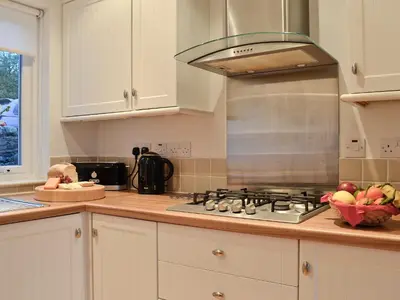 a kitchen with a stove and a bowl of fruit at Bruichladdich in Rothesay