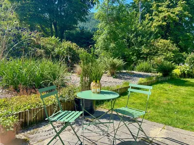 a table and two chairs in a garden at The Heron in Ardentinny