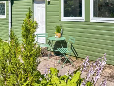 a patio with a table and chairs in front of a house at The Heron in Ardentinny