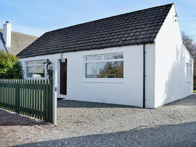 a white house with a fence in front of it at Baravullin in Benderloch