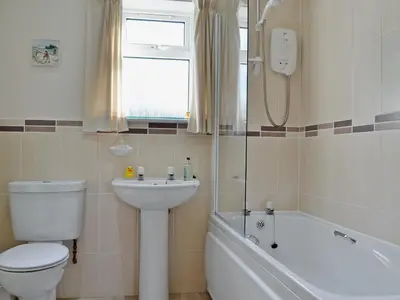a bathroom with a toilet and a sink and a bath tub at Baravullin in Benderloch