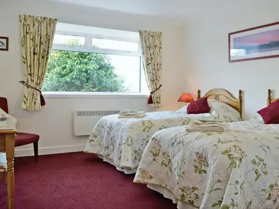 two beds in a room with a window at Baravullin in Benderloch