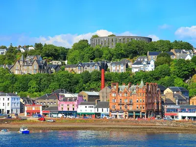 a group of buildings on a hill next to the water at Ferry View in Oban