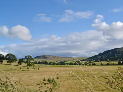 a field of grass with hills in the background at Geordies Byre in Mill of Fortune