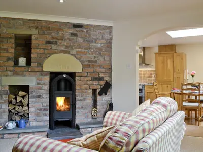a living room with a brick fireplace and two couches at Old Stones in Glendevon