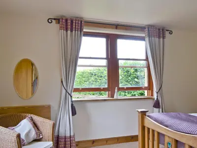 a bedroom with a window with curtains and a crib at Old Stones in Glendevon