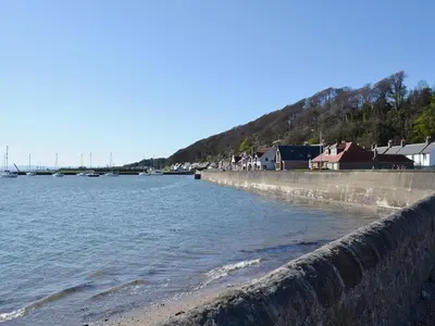 a retaining wall next to a body of water at Ross Cottage in Cairneyhill