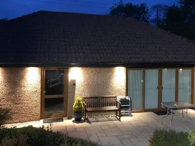 a patio with a bench in front of a building at Eilean Donan in Kirknewton
