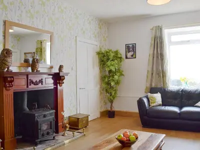 a living room with a couch and a fireplace at Old Barn Farmhouse - Cc in Uplawmoor