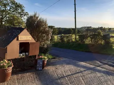 a dog house sitting on the side of a road at Old Barn Farmhouse - Cc in Uplawmoor