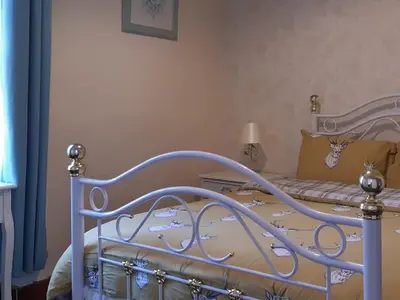 a bedroom with a bed with a blue frame at Old Barn Farm Cottage - Cc in Uplawmoor