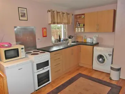 a kitchen with a stove and a washer and dryer at Bramble Cottage 1, 2 & 3 in Lochdon