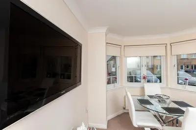 a living room with a large tv and a table and chairs at Dunfermline - Premium Two Bedroom Apartment - KW in Dunfermline