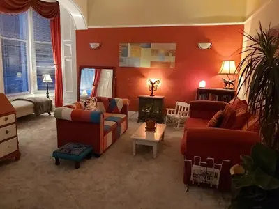 a living room with red walls and couches at The Ben Sheann in Strathyre