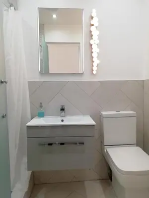 a bathroom with a sink and a toilet and a mirror at The Ben Sheann in Strathyre