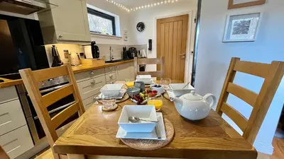 a kitchen with a wooden table with dishes on it at Bluebell Cottage with Hot Tub in Ballachulish