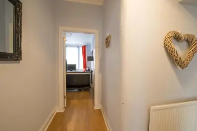 a hallway with a heart hanging on a wall at PREMIER - Crathie View Apartment in Glasgow