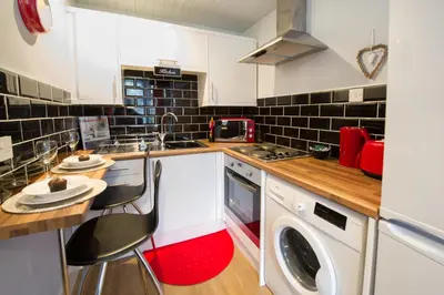 a kitchen with a washer and dryer and a sink at PREMIER - Crathie View Apartment in Glasgow