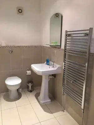 a bathroom with a sink and a toilet and a mirror at Lanark Residence in Edinburgh