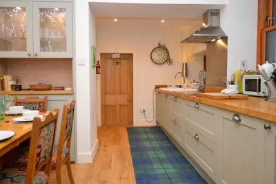 a kitchen with a table and a counter top at Aldersyde in Tighnabruaich