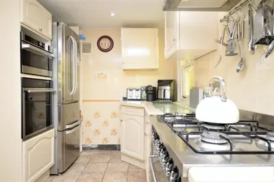 a kitchen with white cabinets and a stove top oven at Ardmun House in Dunoon