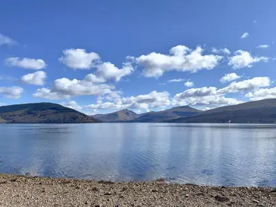 a view of a lake with mountains in the background at Newton Cottage South in Inveraray