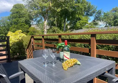 a table with a bottle of wine and wine glasses at Loch View Lodge in Dunoon