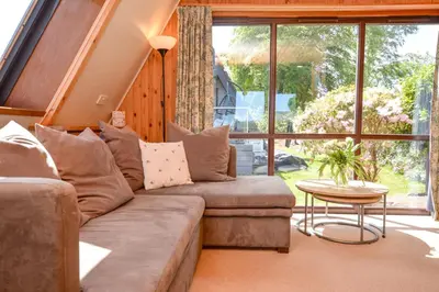 a living room with a couch and a table at Loch View Lodge in Dunoon