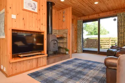 a living room with a tv and a fireplace at Loch View Lodge in Dunoon