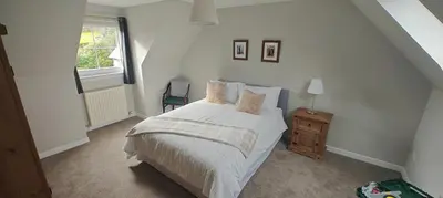 a bedroom with a bed and a window at Ben Lomond Cottage in Arrochar