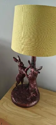 a bronze lamp on a table with a lamp shade at Ben Lomond Cottage in Arrochar
